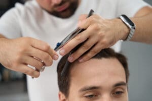 El peluquero corta el pelo con cuidado